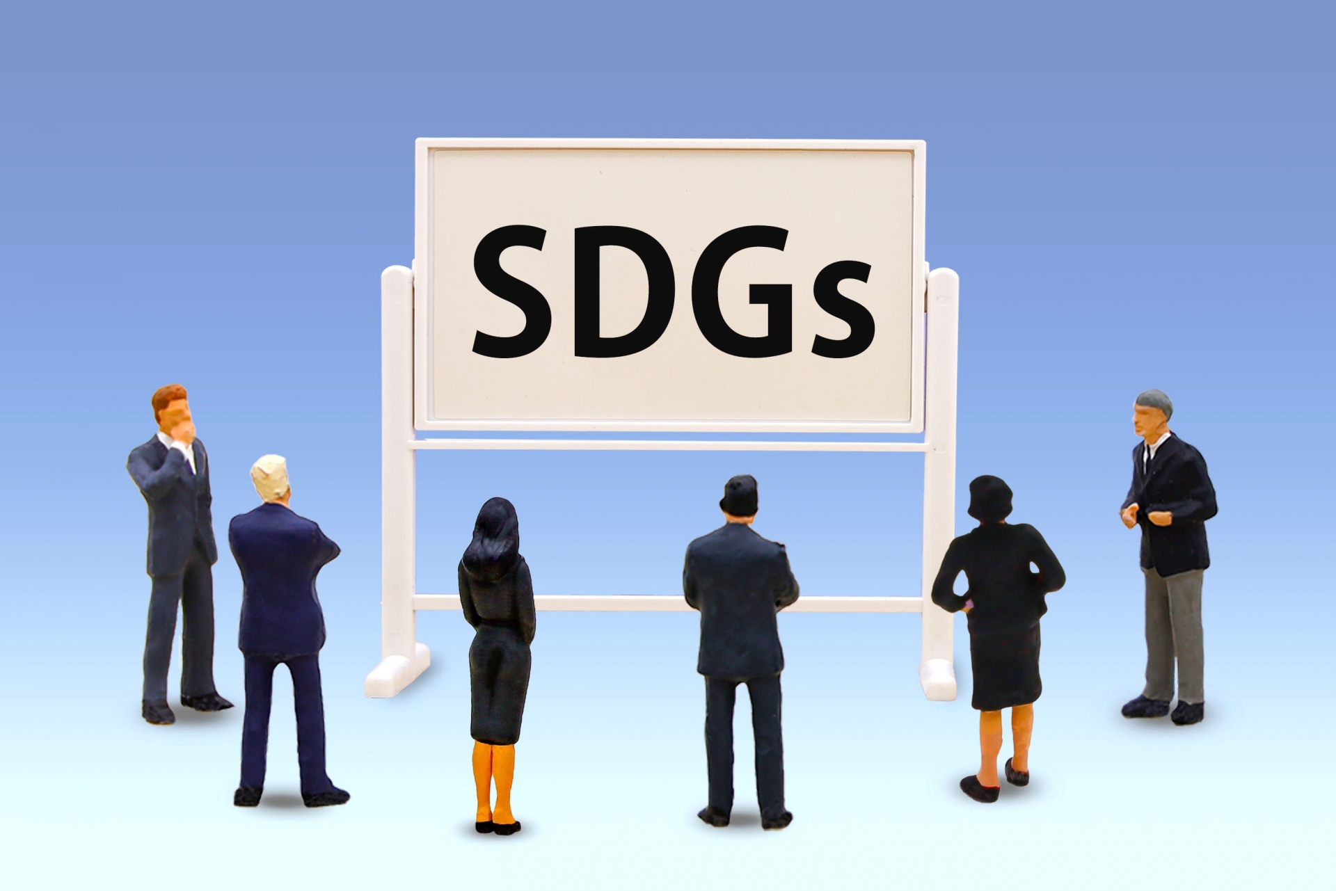 SDGsの掲示を前に立ち止まる人々